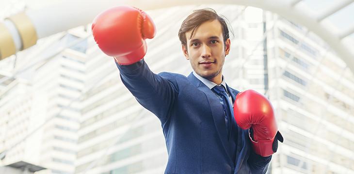 Battere la concorrenza uomo che indossa guantoni da boxe