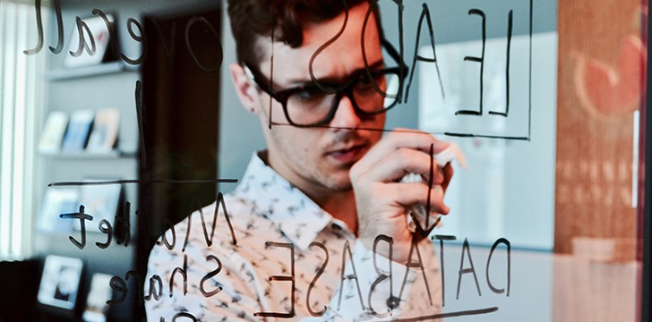 ragazzo scrive su parete di vetro