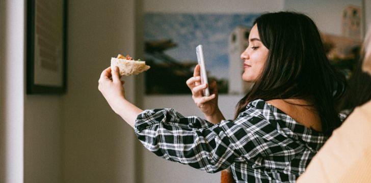 Food influencer fotografa una pizza